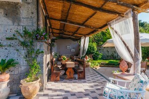 Un patio al aire libre con piso a cuadros, muebles de madera y plantas en macetas.