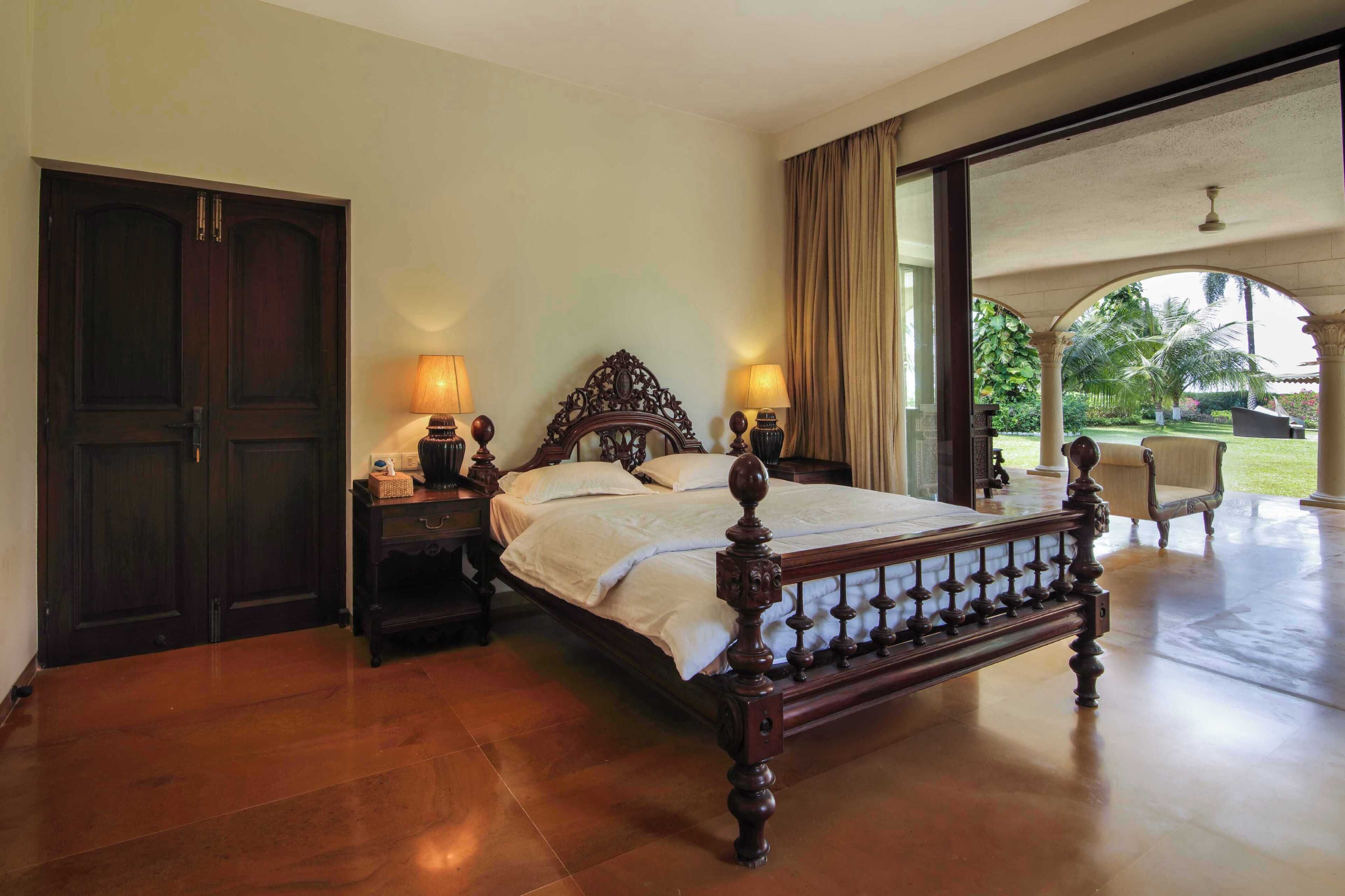 A spacious bedroom with a large bed, wooden headboard, and two bedside lamps.