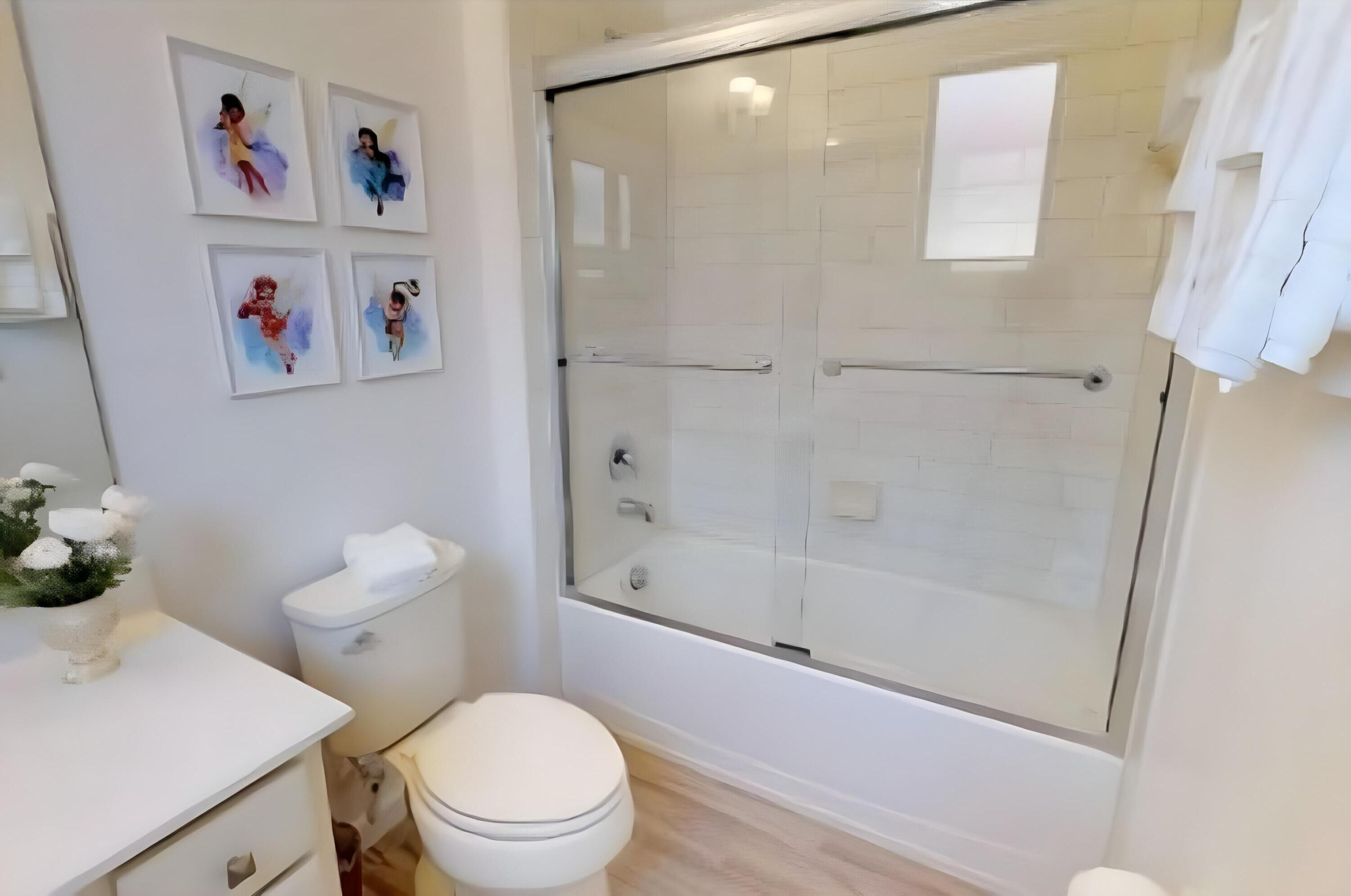 Un bagno moderno con doccia vetrata, un water e un lavandino.