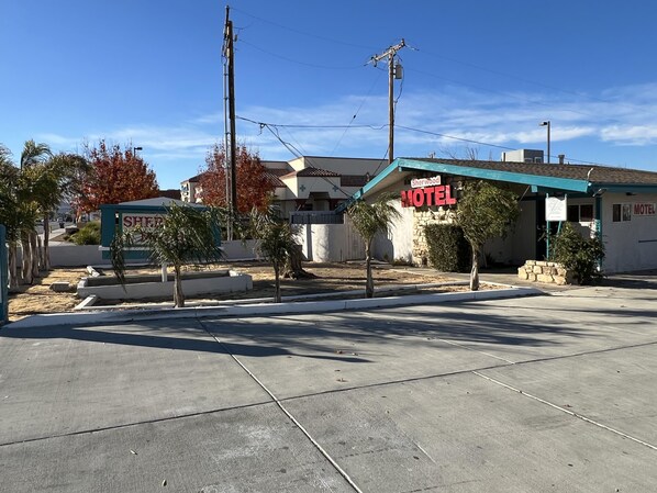 A motel with a sign reading "Sherwood Motel" and a small parking lot in front.