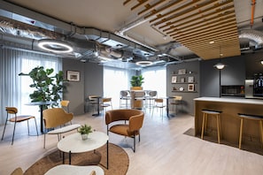Meet and collaborate in a functional office space with a central seating area, bar, and kitchenette.