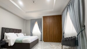 Een moderne hotelkamer met een groot bed, een houten garderobe en een radiator.