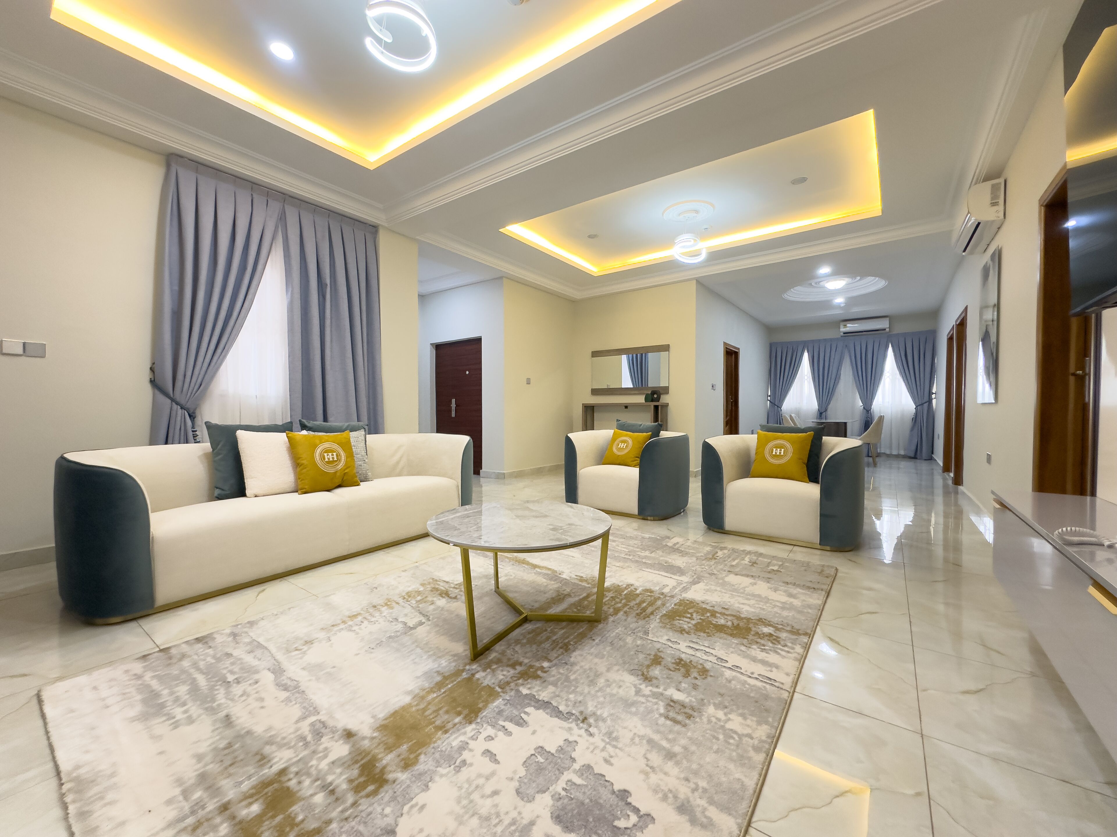 A modern living room with a sofa set, a coffee table, and a dining area.