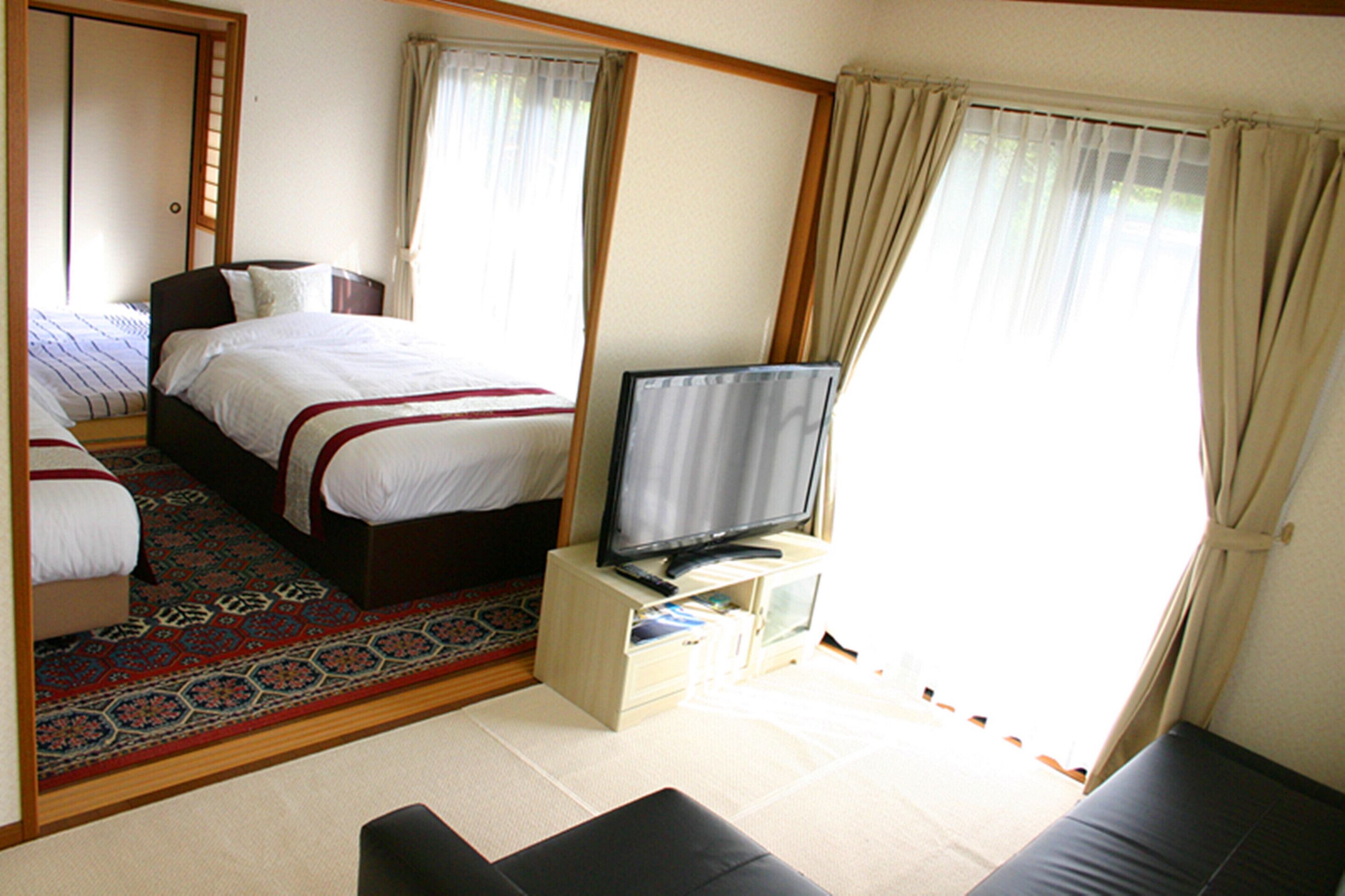 Een hotelkamer met een bed, een televisie en een bank.