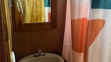 A bathroom with a wooden vanity, a sink, and a mirror.