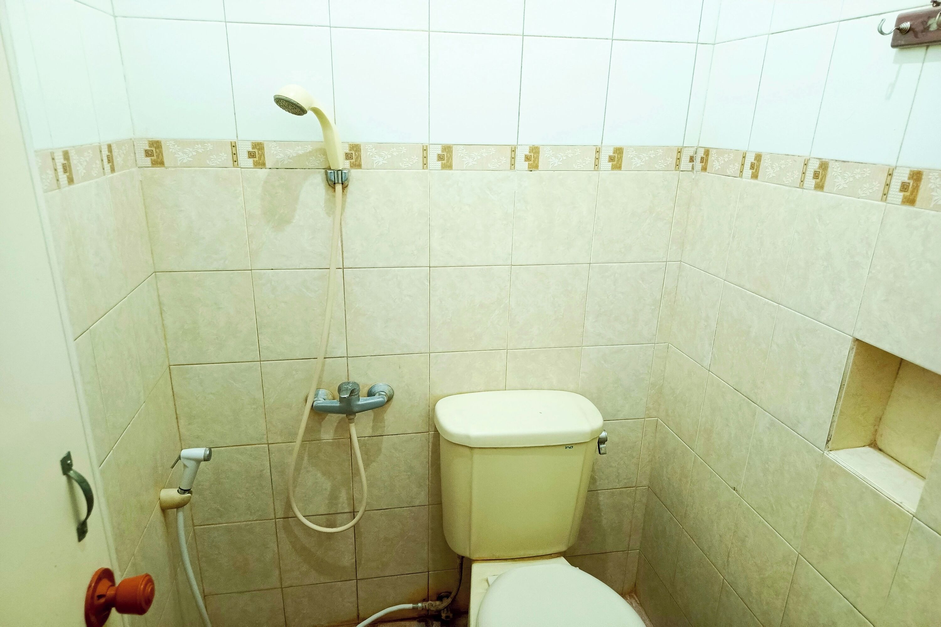 Ein kleines Badezimmer mit Toilette, Dusche und Handtuchhalter.