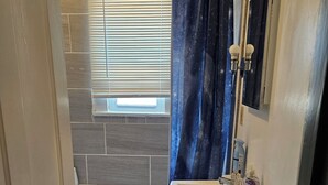 Ein Badezimmer mit Badewanne, Waschbecken, Spiegel und Duschvorhang.