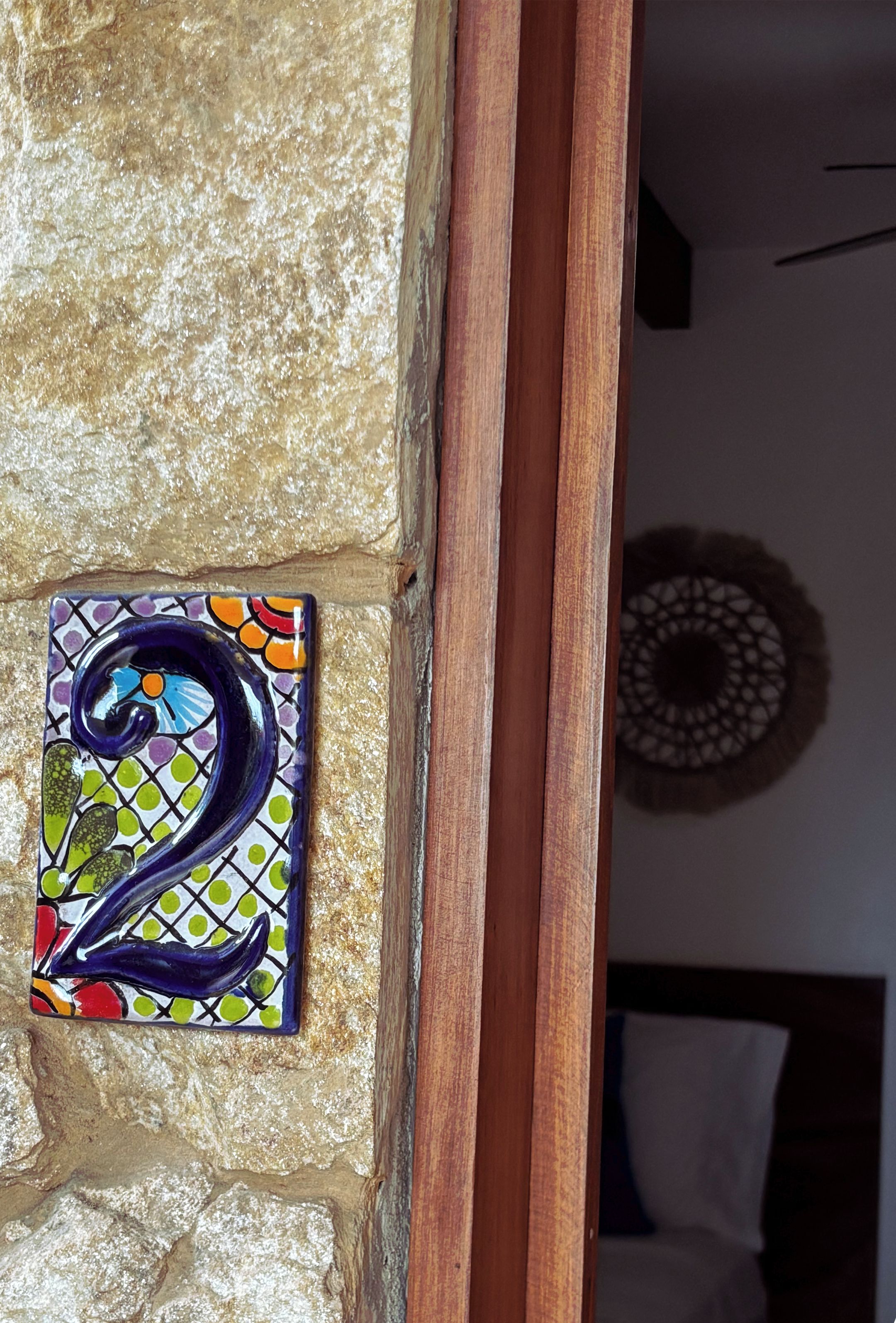 A stone wall with a colorful number '2' sign.