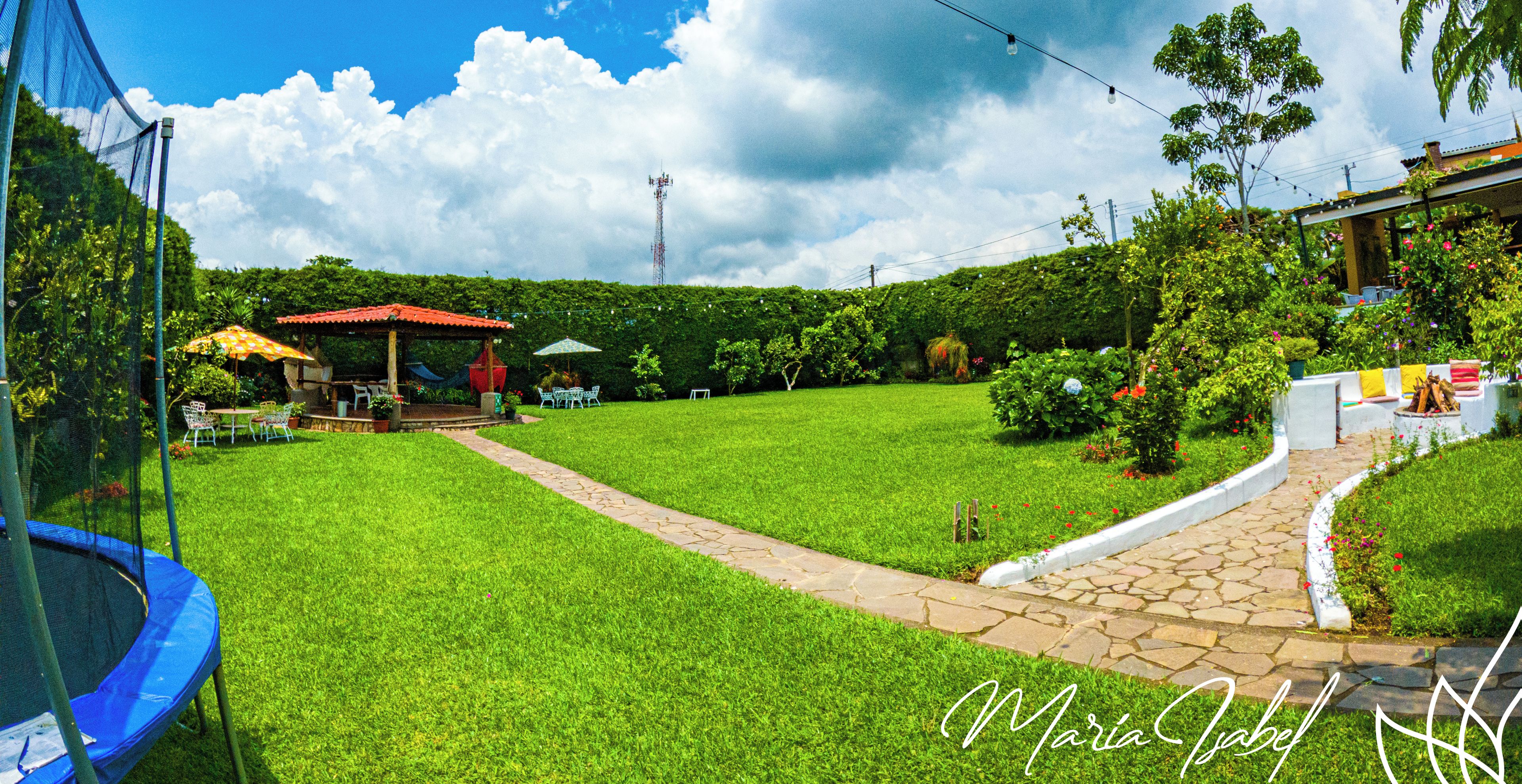 A well-maintained lawn with a stone pathway, a gazebo, and outdoor seating.