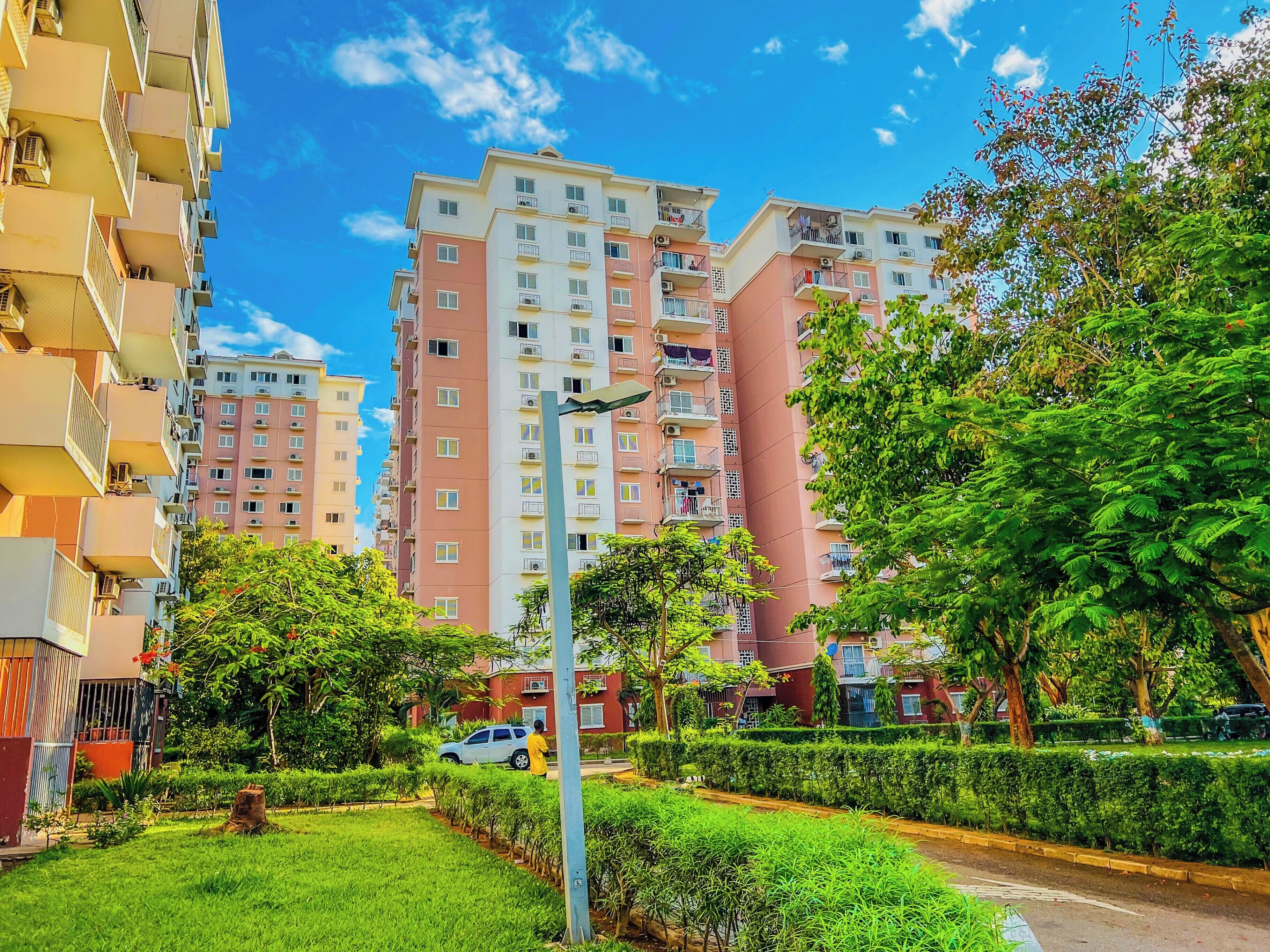 A residential building with multiple floors, balconies, and a well-maintained garden area.