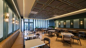 A spacious dining area with high ceilings, modern lighting, and a variety of seating options including tables and benches. - Valstar Hotel Canggu (Canggu)