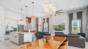 A modern kitchen with white cabinets, stainless steel appliances, and a central island. - Fairway Prosperity: Arcade, Themed Bedroom, Golf, Private Pool, Near Disney (Kissimmee)