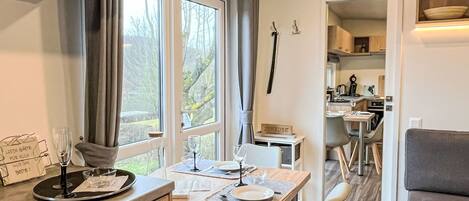 Uma cozinha moderna com área de refeições, janelas amplas e um espaço de estar acolhedor.