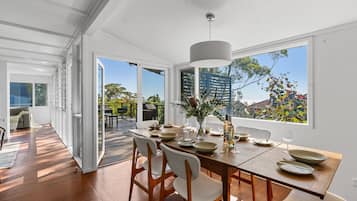 Enjoy meals in this dining area with a table for four, overlooking the outdoors through large windows.