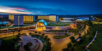 Un moderno complejo hotelero con varias edificaciones, un patio central y una piscina.