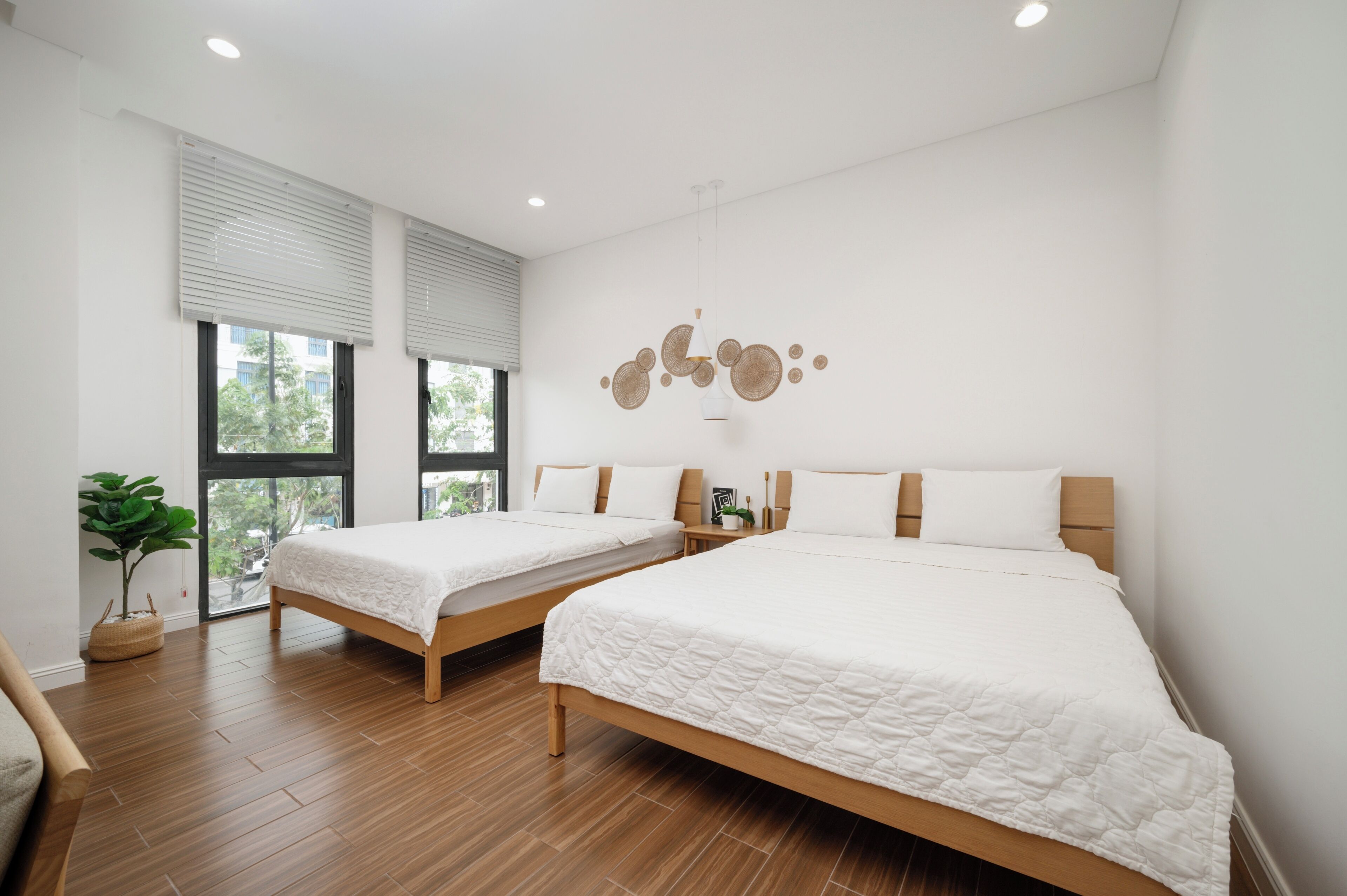Un dormitorio moderno con dos camas, ventanas amplias y una decoración minimalista.