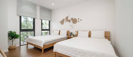 Un dormitorio moderno con dos camas, ventanas amplias y una decoración minimalista.