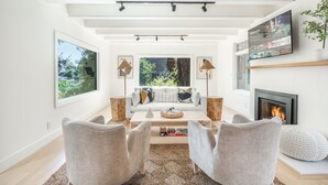A modern living room with a sofa, two armchairs, a coffee table, and a fireplace. - Secluded Downtown Modern Lux Retreat in Redwoods (Mill Valley)