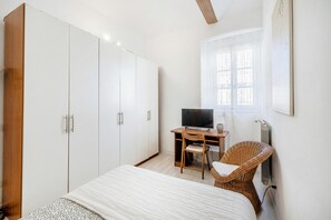 Ein Schlafzimmer mit Bett, Schreibtisch mit Stuhl, Fernseher und Fenster mit Blick.