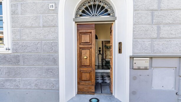 A white brick building with a wooden door and a number '15' sign. - Ardenza's Aires 600m From Sea (Livorno)