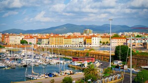 A marina with numerous boats docked, surrounded by colorful buildings and a clear sky. - Ardenza's Aires 600m From Sea (Livorno)