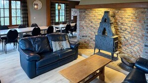 Un salon chaleureux avec un canapé en cuir, une table basse en bois et une cheminée en pierre.