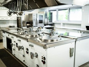 Een koelkast, een oven, een broodrooster, kookgerei, borden en bestek