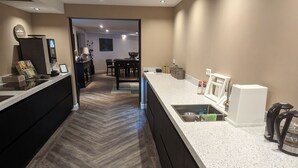 A modern kitchen with a herringbone floor, a large island with a sink, and a dining area in the background. - Gruppe Meisenberg by Interhome (Winterberg)