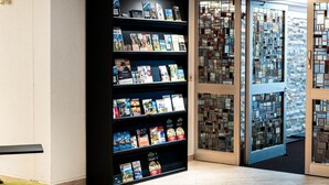A modern library with bookshelves, a green seating area, and a glass door entrance. - Gruppe Meisenberg by Interhome (Winterberg)