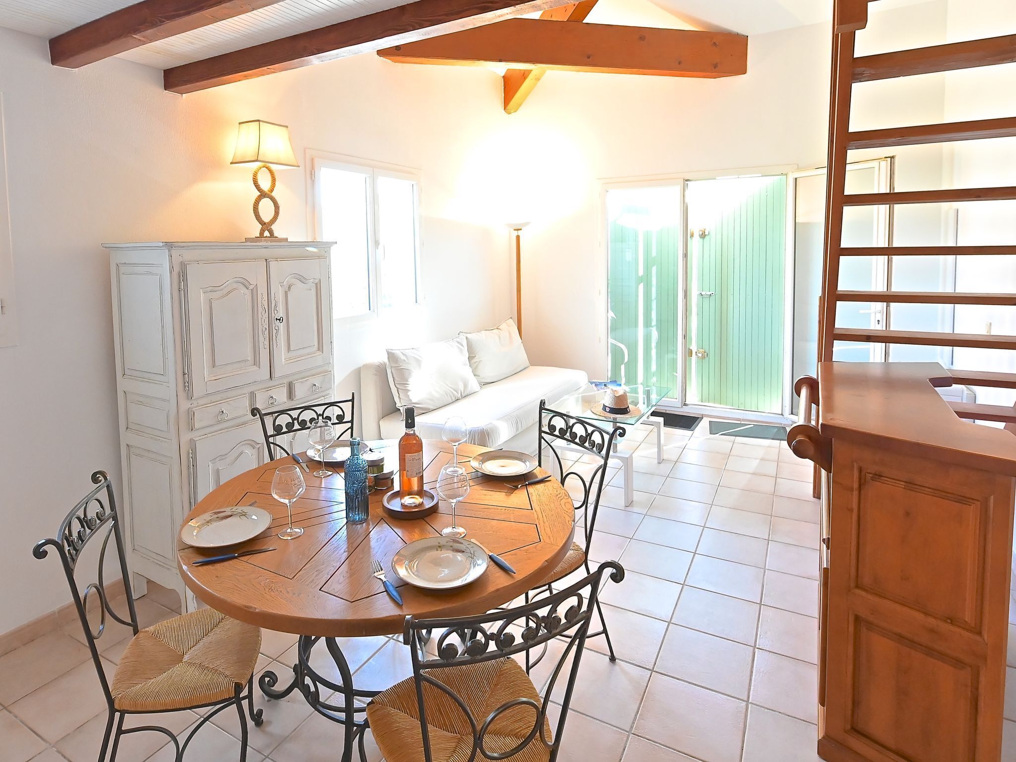 A dining area with a round wooden table, metal chairs, and a cabinet.
