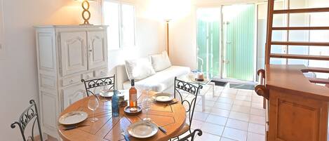 A dining area with a round wooden table, metal chairs, and a cabinet.