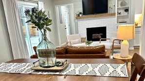 A dining area with a wooden table, chairs, and a vase of flowers. - Fort Smith / Furnished 4 BR / Nurses, Ebbing, TDY (Fort Smith)