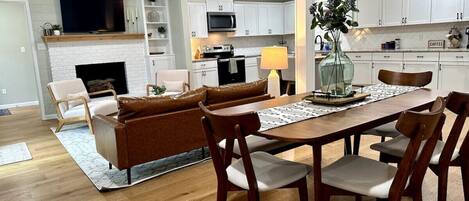 Una cocina moderna con armarios blancos, microondas y una zona de café.