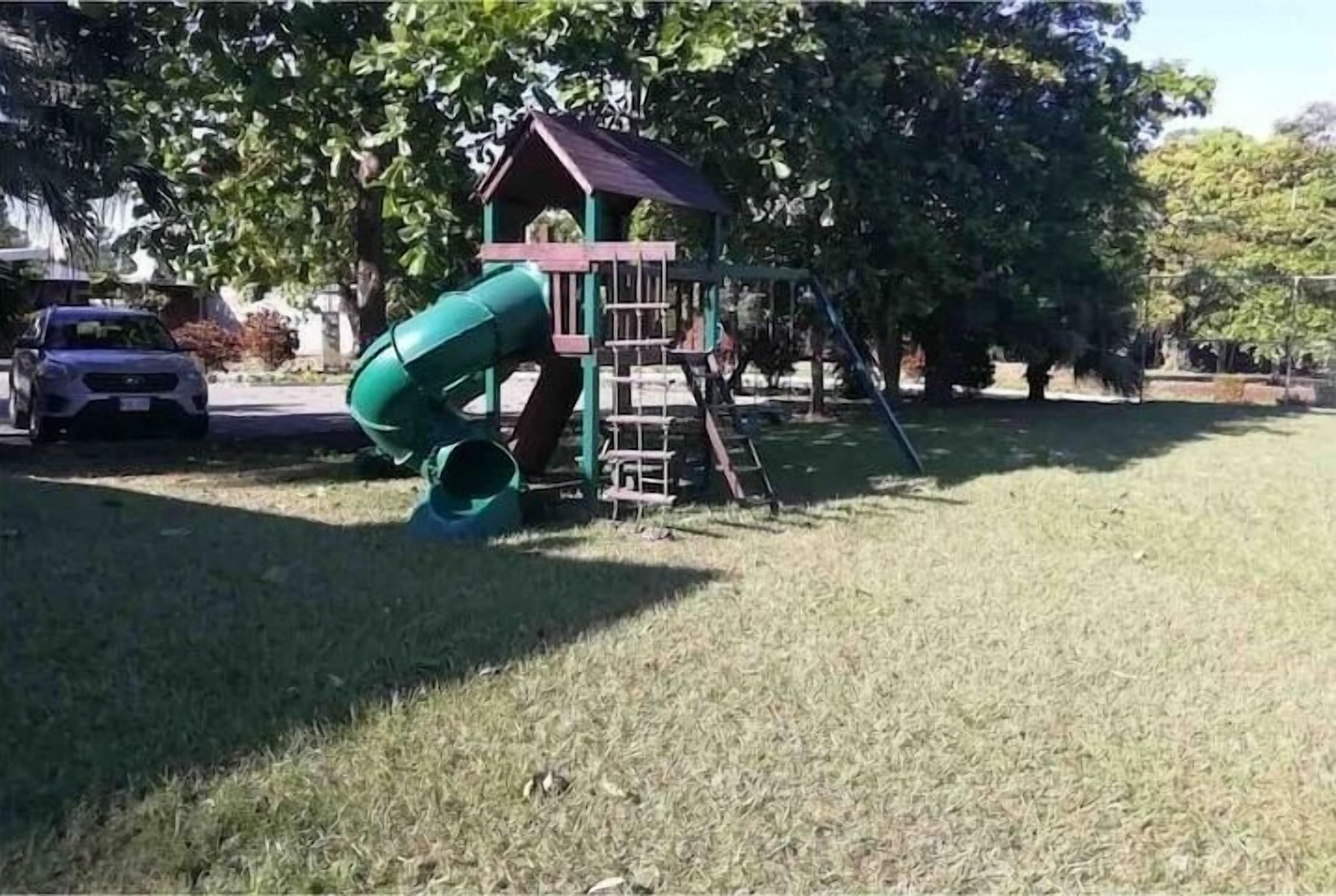 A playground with a slide and climbing structures.