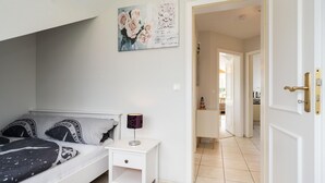 Un dormitorio con una cama, una mesita de noche y un cuadro en la pared.
