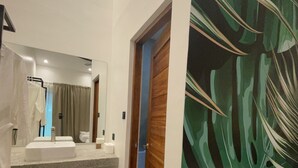 A bathroom with a sink, mirror, and a shower curtain. - Bahandi Hotel (General Luna)