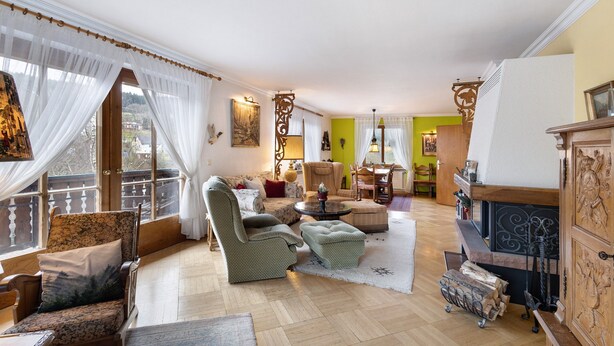 Un salon spacieux comprenant un canapé, des fauteuils, une table basse et une cheminée.