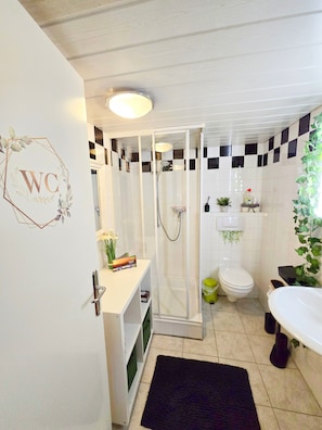A bathroom with a shower, toilet, and sink.