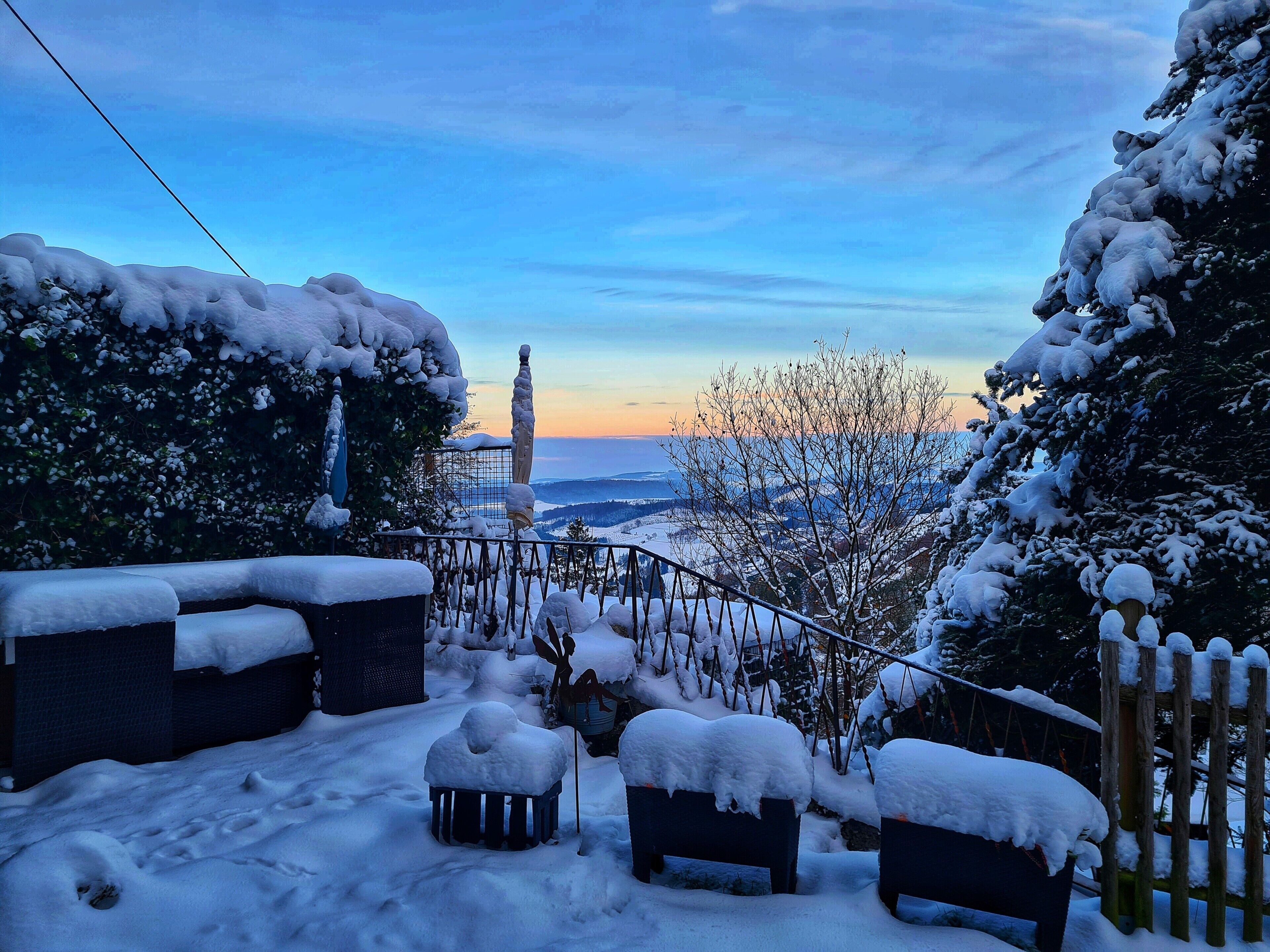 Ein verschneiter Außenbereich mit Blick auf eine entfernte Landschaft.