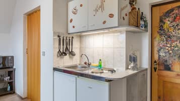 Una cucina con lavastoviglie integrata, macchina del caffè e lavello con rubinetto moderno.