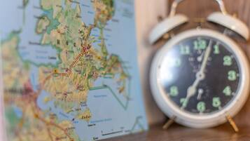 A map and an alarm clock on a wooden surface.