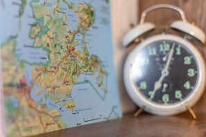 A map and an alarm clock on a wooden surface.