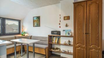 Une pièce chaleureuse avec un meuble en bois, une table, un banc et une bibliothèque.