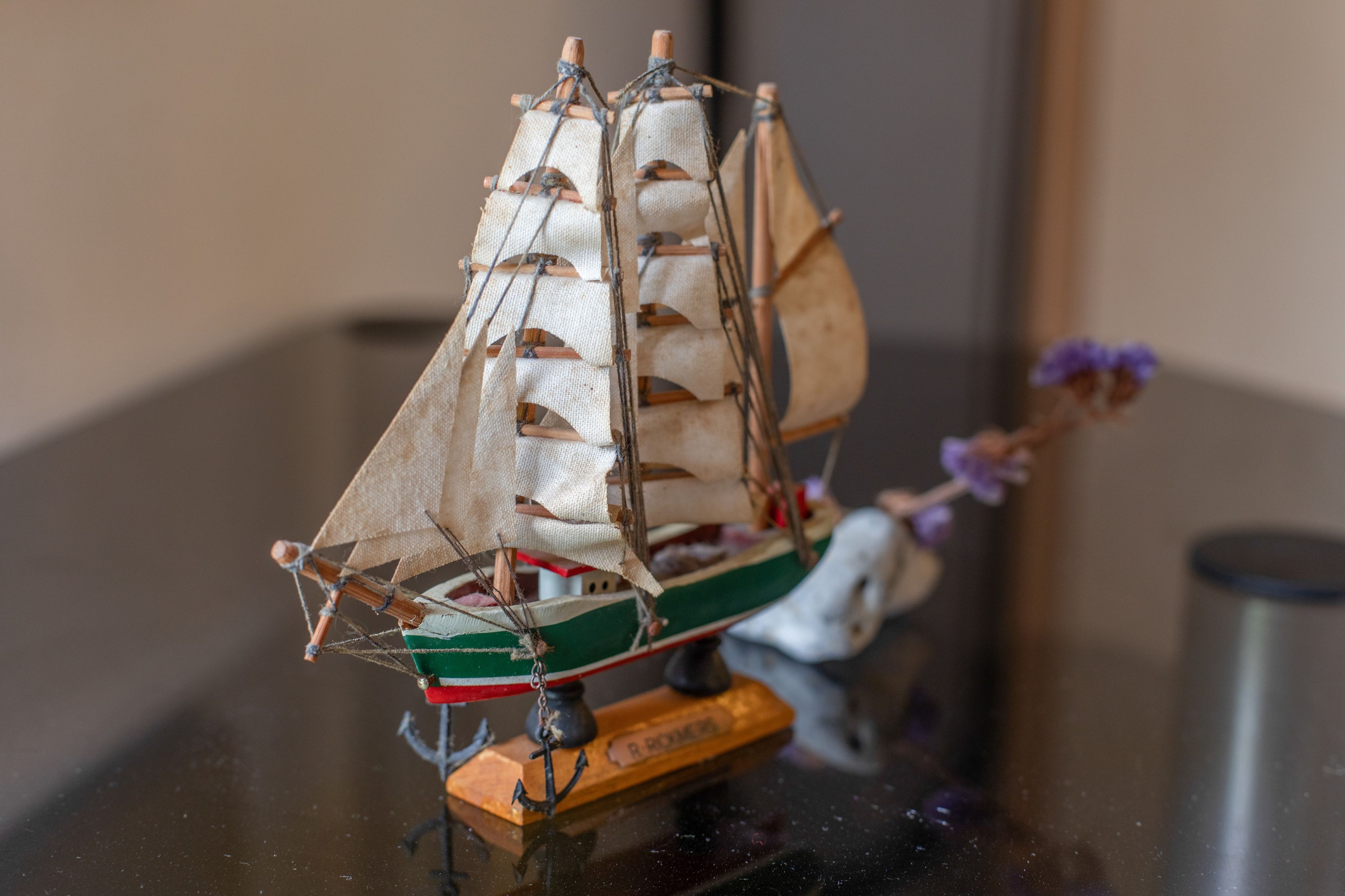 Un model de vaixell sobre un pedestal amb una placa amb el nom.