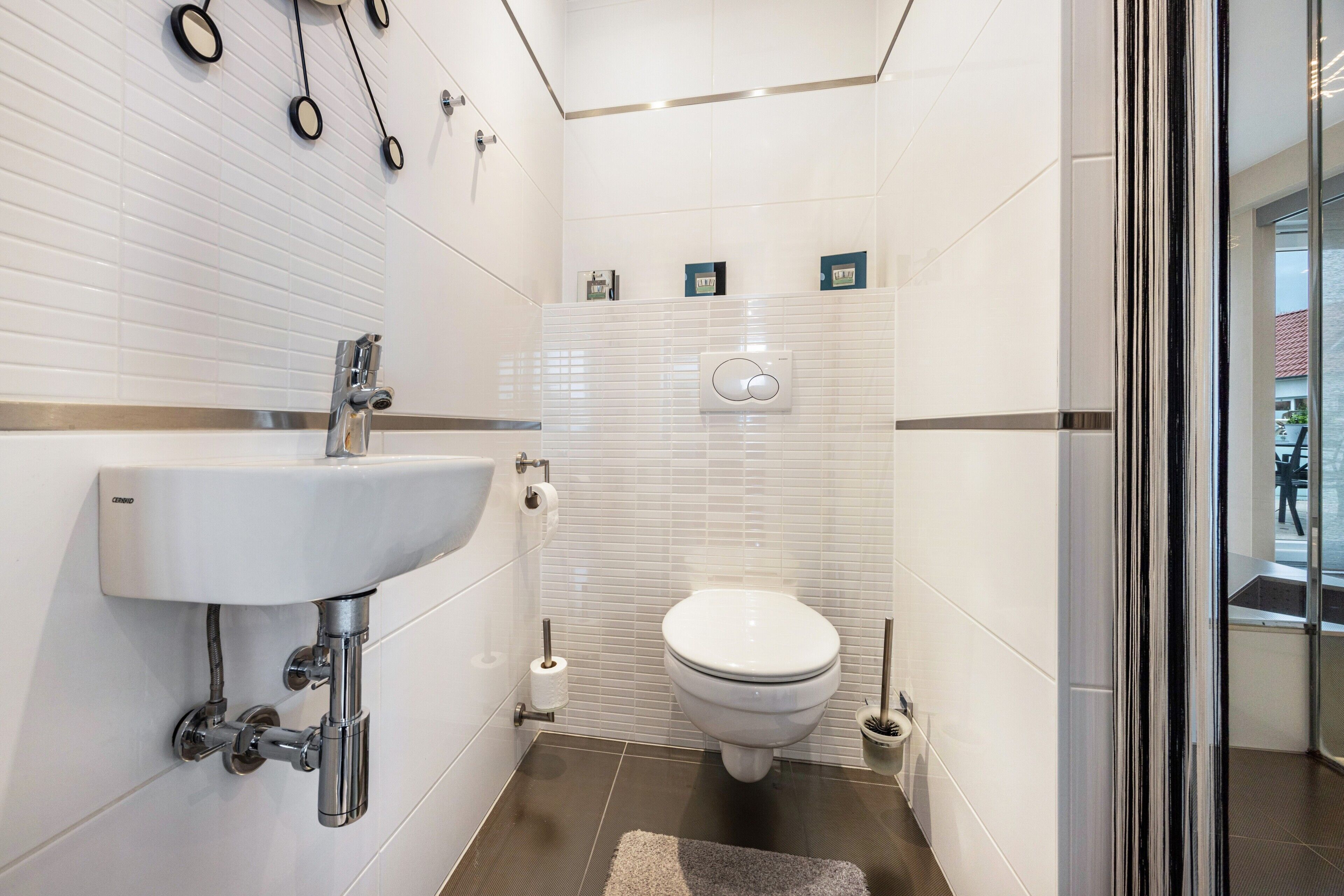 Ein modernes Badezimmer mit Waschbecken, Toilette und Bidet in Weiß.
