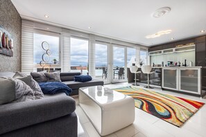 Una sala de estar moderna con un sofá, una mesa de centro y un tapete colorido.