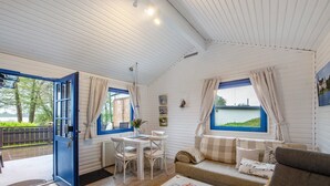 Una habitación acogedora con una mesa de comedor, sillas, un sofá y vistas al exterior.