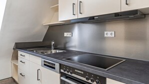 Una cocina moderna con electrodomésticos de acero inoxidable, un lavamanos doble y un horno empotrado.