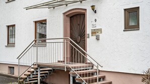 Un edificio con una escalera que conduce a una puerta, un pequeño toldo y un letrero con el número 9.
