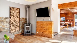 Een modern interieur met een stenen muur, een open haard, een flatscreen televisie en een eethoek.